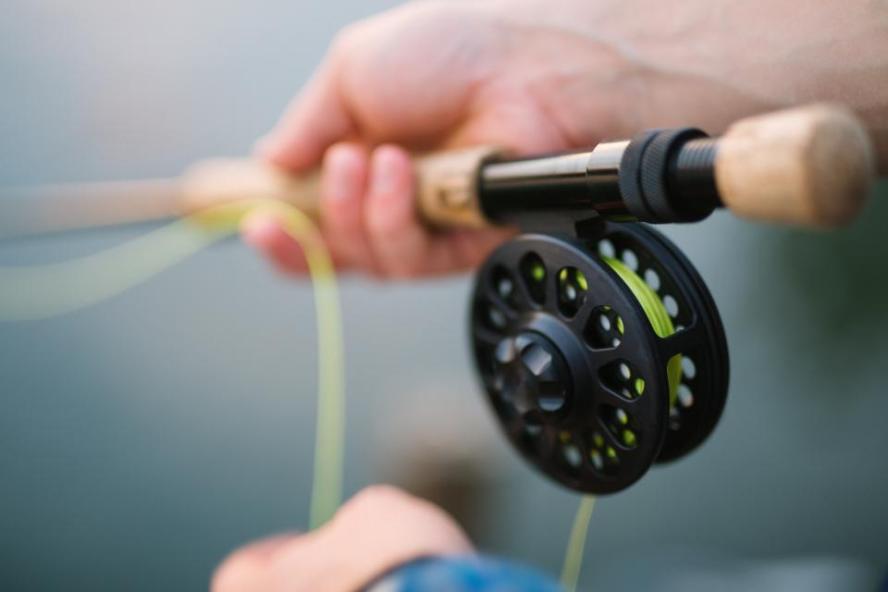 fly fisherman holding fly pole for fly fishing