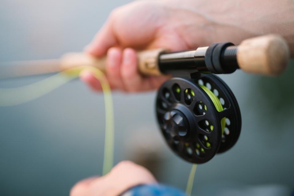 hand holding fly rod with real