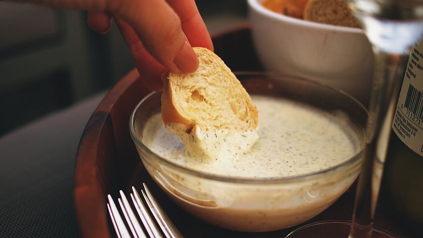 Smoked salmon dip with a bread being dipped 